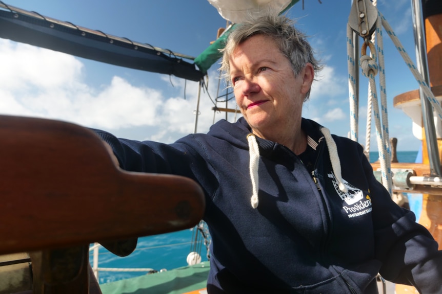 a woman on a moving yacht stares off into the distance