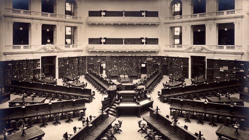 A grand reading room with balconies and long desks.