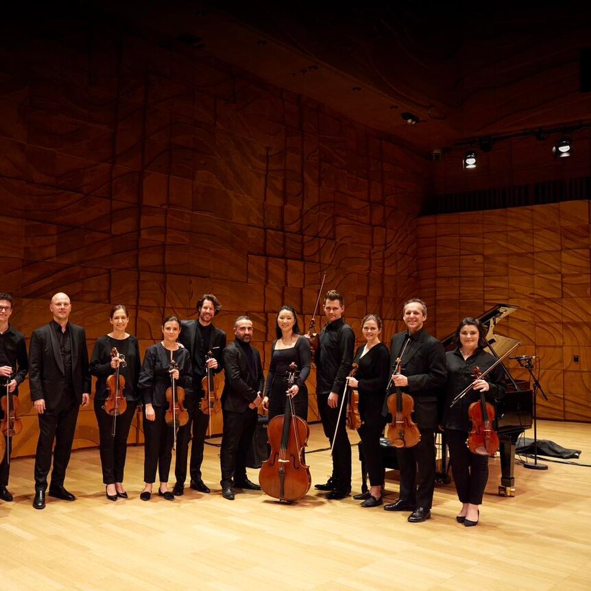 Omega Ensemble poses onstage at the Melbourne Recital Centre's Elisabeth Murdoch Hall with guest violinist Thomas Gould.