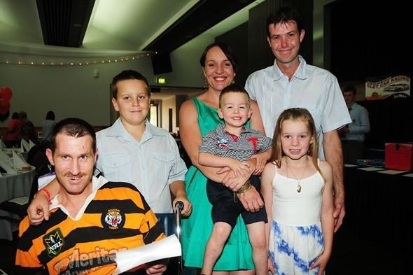 A family group including a man in a wheelchair and a children and two other adults