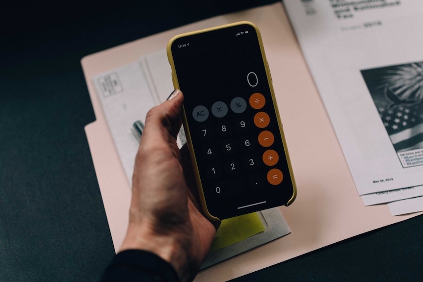 Woman holding her phone with the calculator open