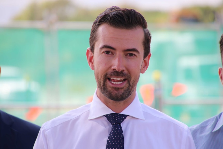 A close up photo of WA Liberal leader Zak Kirkup in front of a green background.