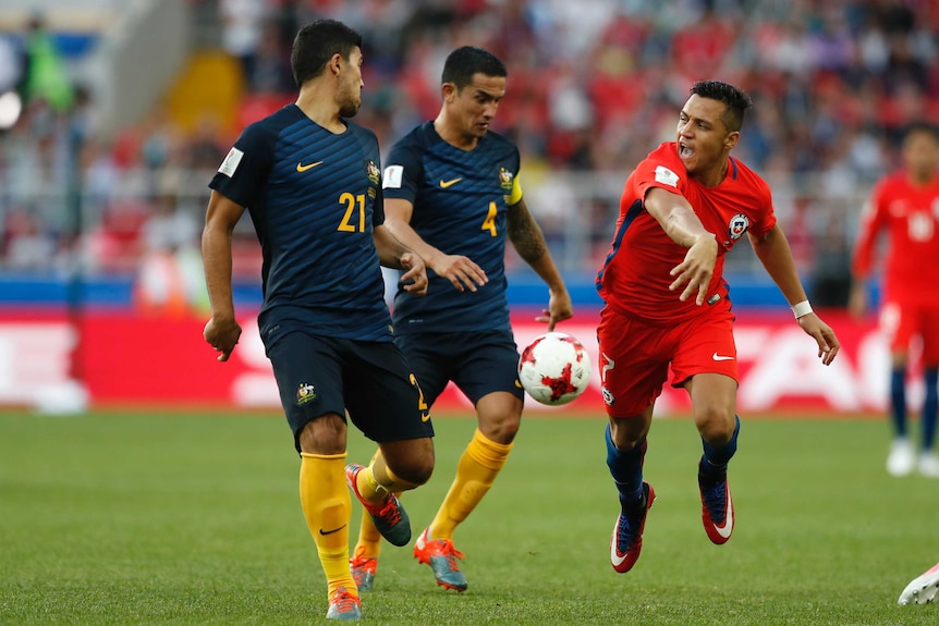 Chile's Alexis Sanchez fights for the ball against Australia's Tim Cahill at Confederations Cup