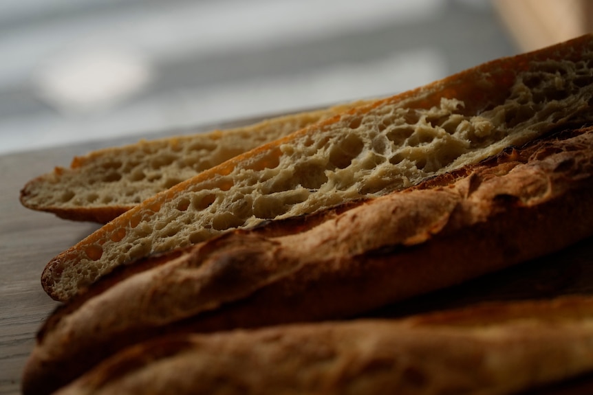 A close-up image of four baguettes lying on a table