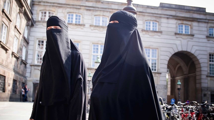 Women in niqab walk, in front of the Danish Parliament at Christiansborg Castle.