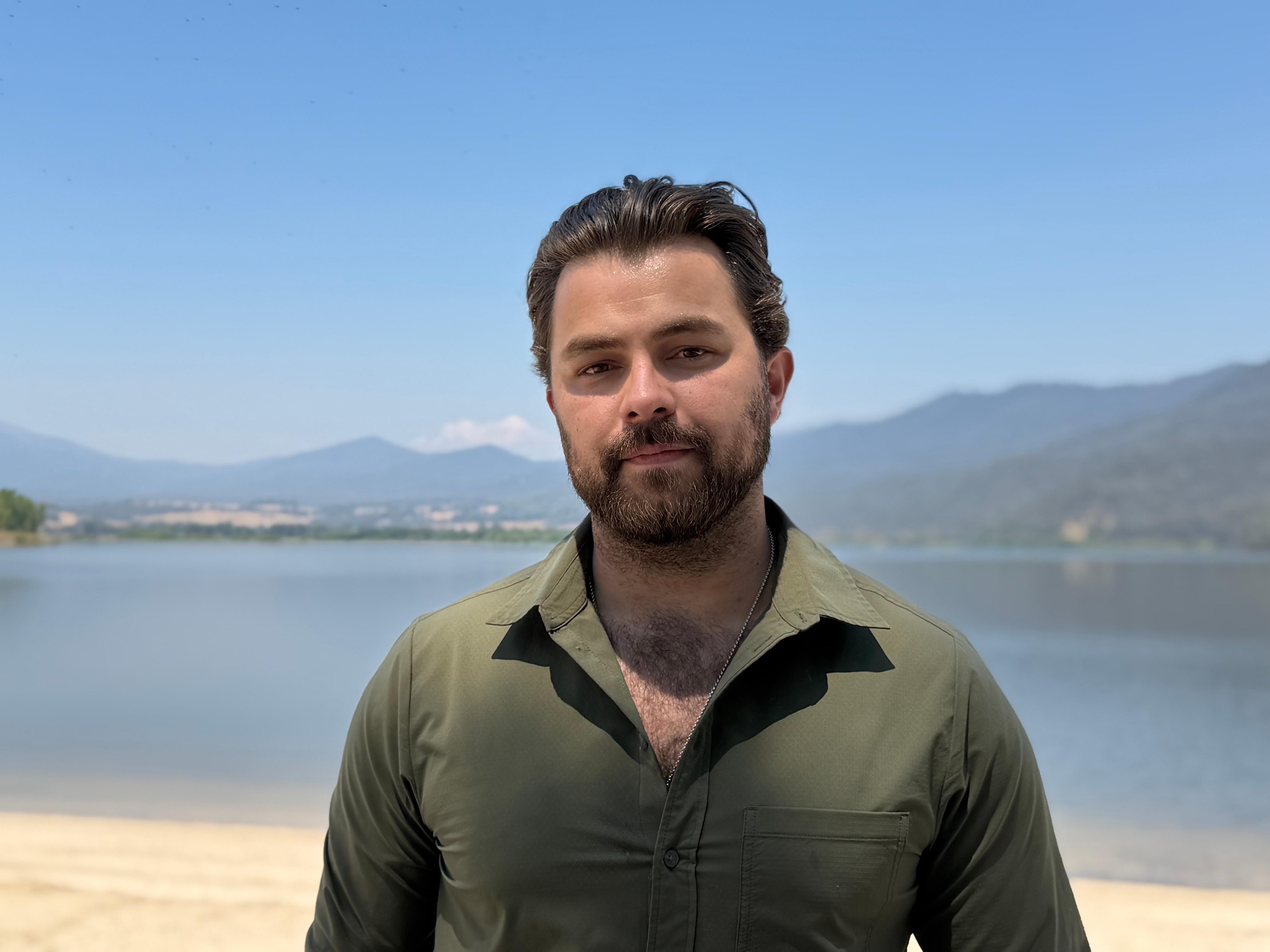 Un hombre sonríe a la cámara.