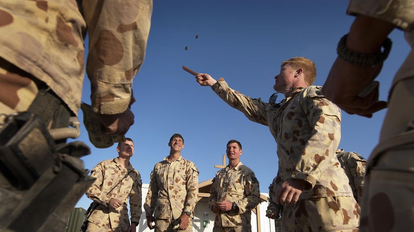 Soldiers in Afghanistan play two-up