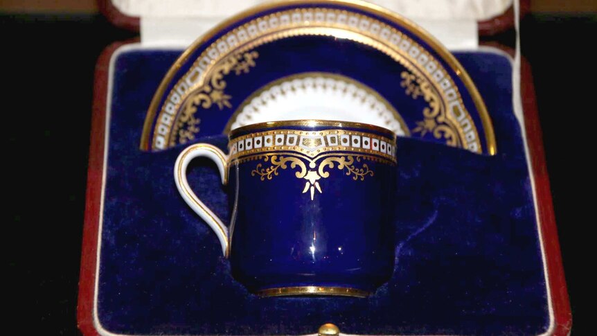 A gold and blue cup and saucer.