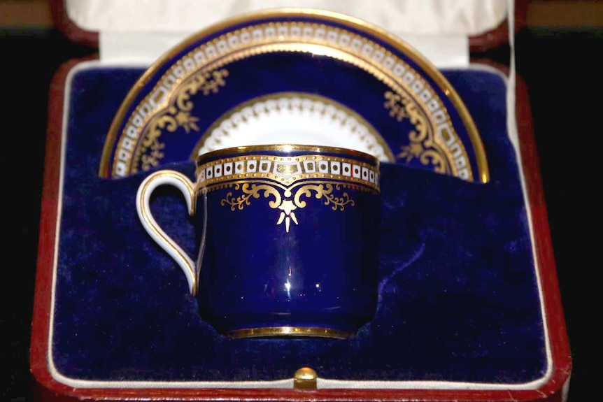 A gold and blue cup and saucer.