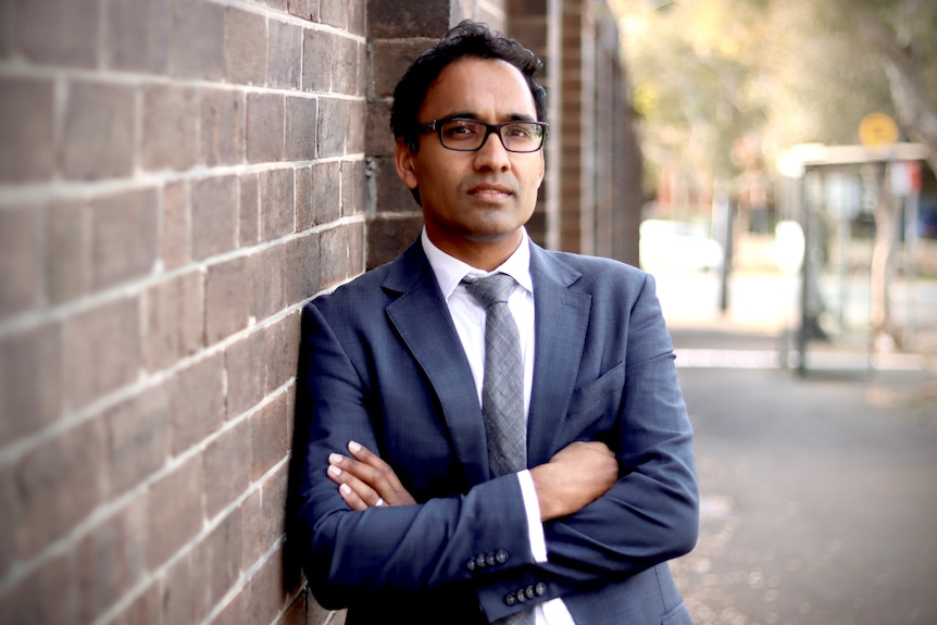 A man in suit stands.