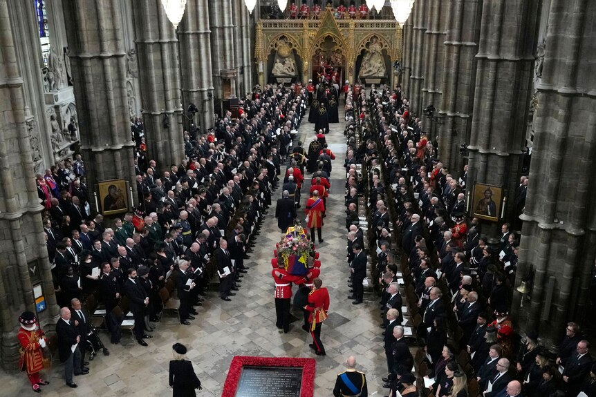 The Queen's coffin is carried by military into the abbey 