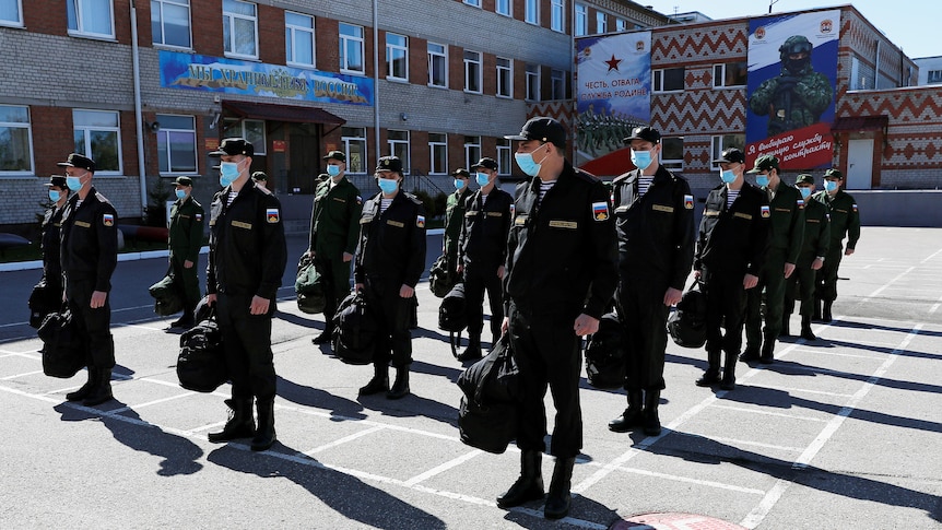 A group of men wearing masks stand in a line.