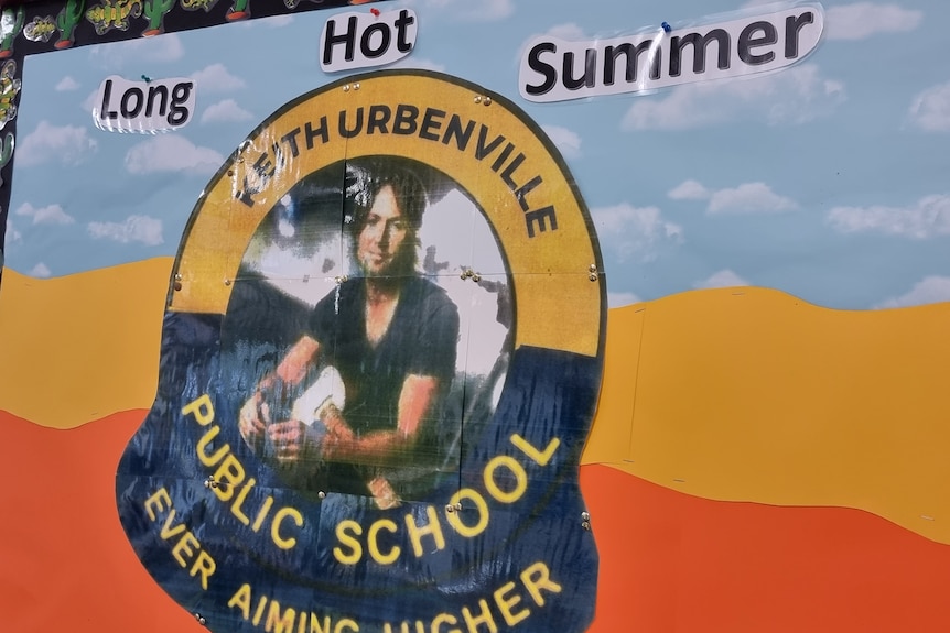 A poster of a school logo with Keith Urban in the middle