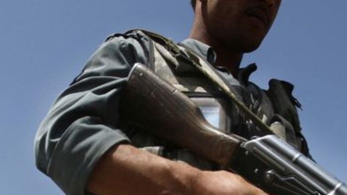 Afghan policeman patrols site