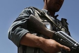 Afghan policeman patrols site
