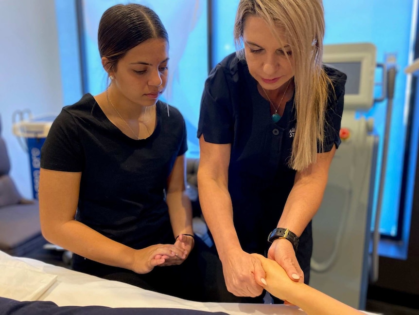 Marion teaching Kimberley how to hand massage