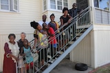 Family from Africa standing on stairs smiling together.