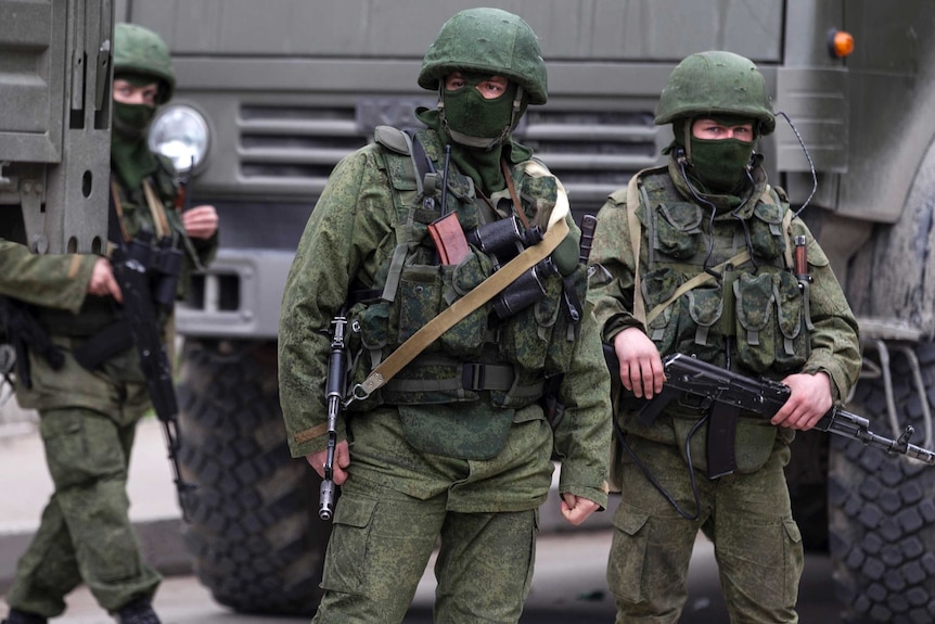 Troops stand near Russian army vehicles in Crimea