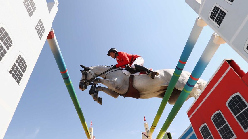 Martin Fuchs and his horse leap over a jump at the Rio Olympics.