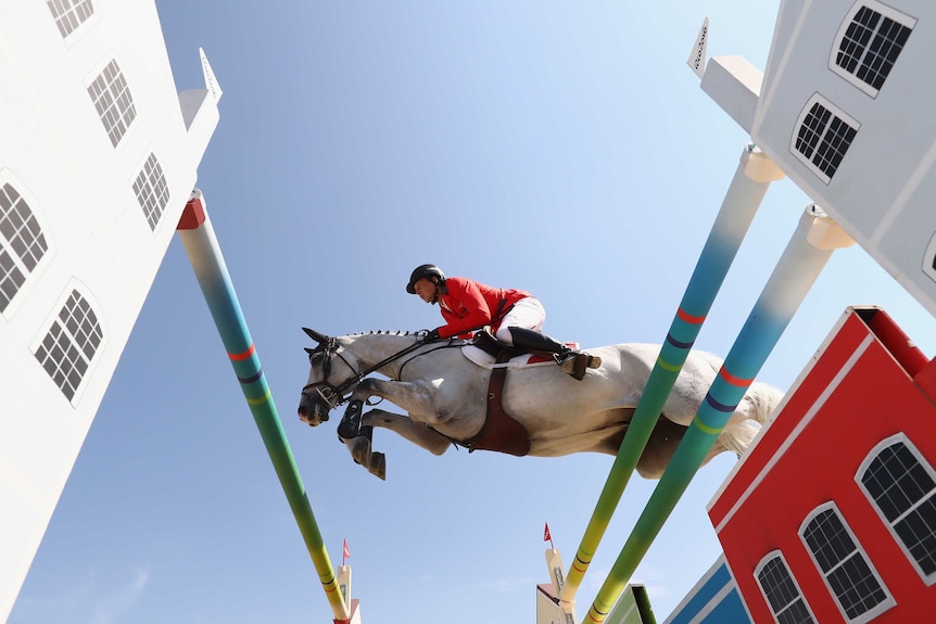 Martin Fuchs and his horse leap over a jump at the Rio Olympics.