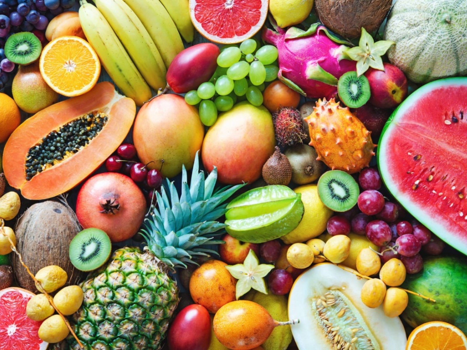 An assortment of tropical fruit including grapes, pineapple, watermelon, mangoes and kiwis