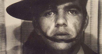 A tight black and white head shot of an Indigenous man in an Australian