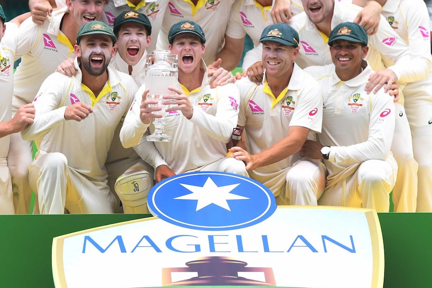 The Australian cricket team celebrate with the Ashes trophy.