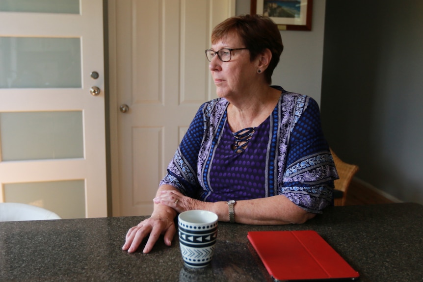 Jennifer Lyons sits at the kitchen table with her ipad.