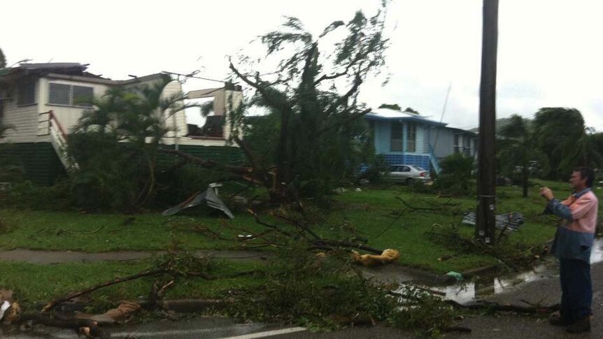 A local surveys the damage left by a 'mini-tornado' that hit Townsville