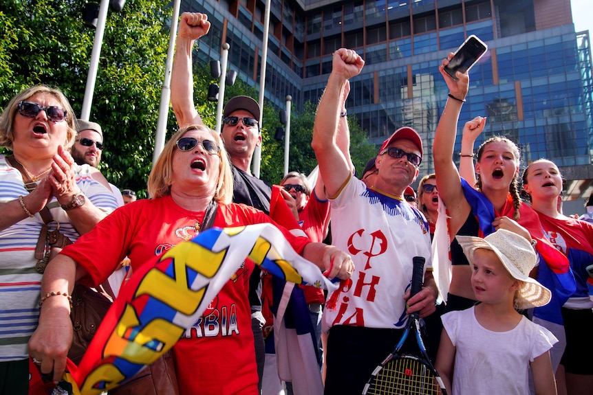 Djokovic fans raise their fists and chant in solidarity with the tennis player outside court, January 10, 2022.