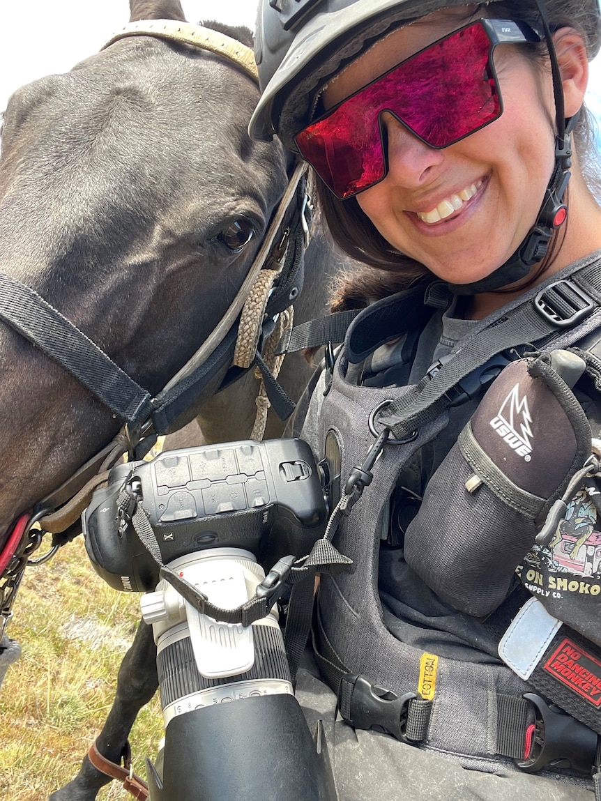 Kathy Gabriel takes a selfie with a horse and her camera equipment.