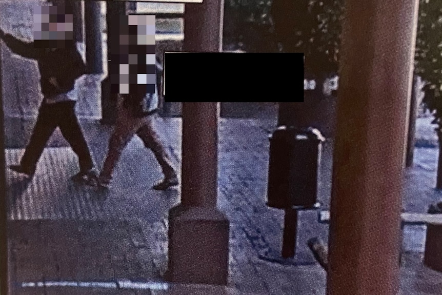A CCTV image of two people with their faces blurred.