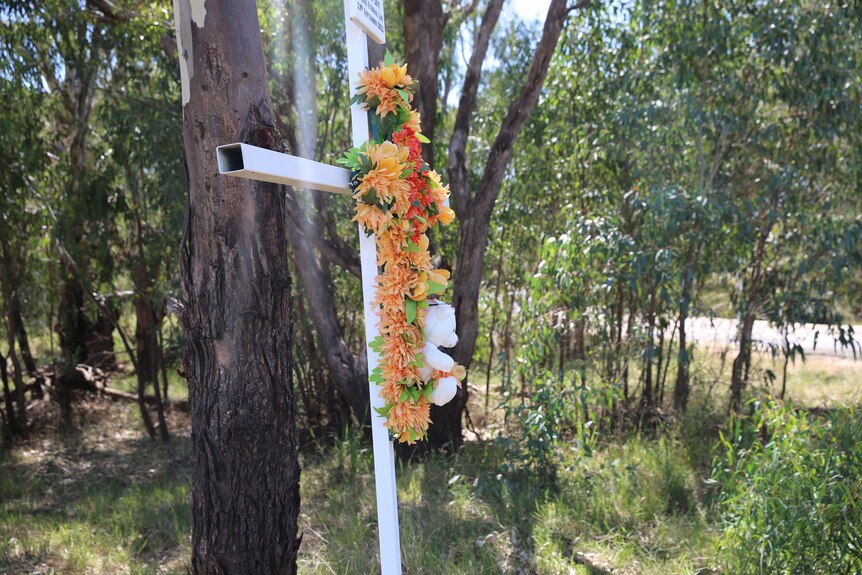 A memorial cross and flowers.