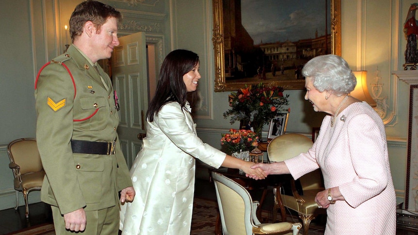 The Queen greets Corporal Daniel Keighran and his wife Kathryn at Buckingham Palace.