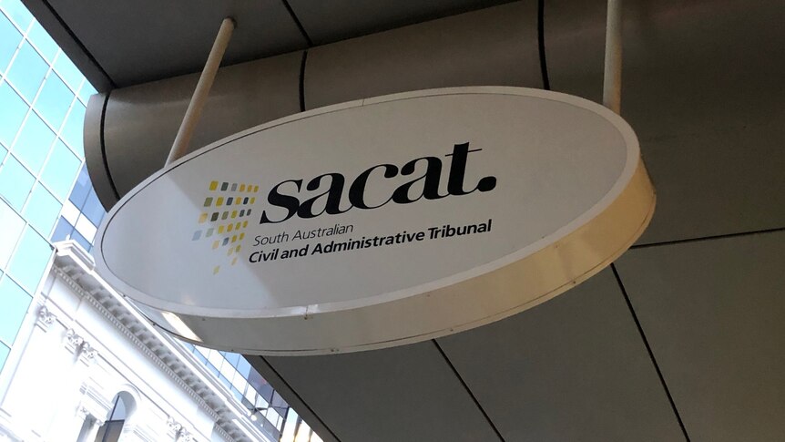 An oval sign under a shop verandah saying sacat.