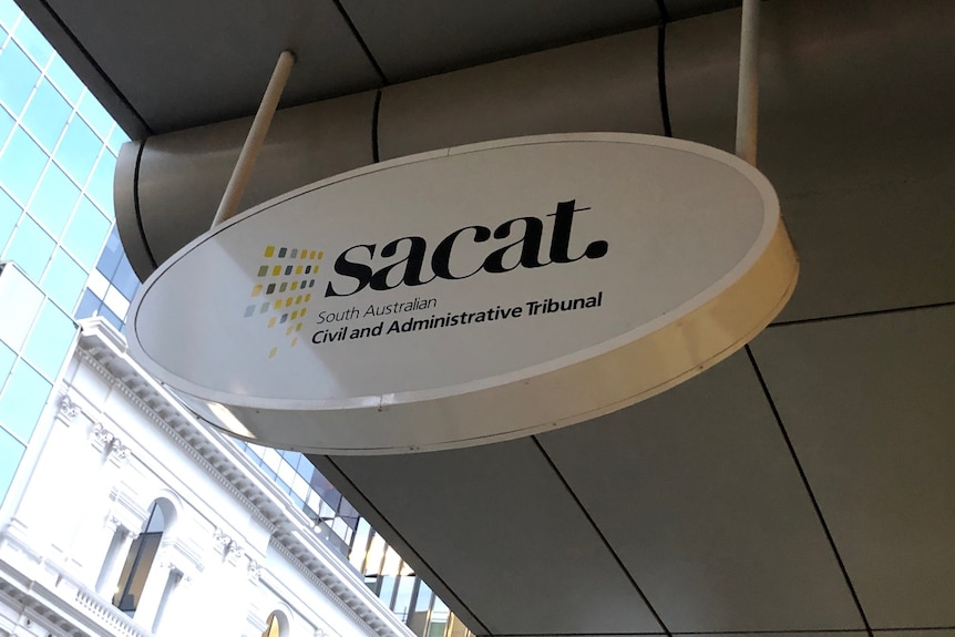 An oval sign under a shop verandah saying sacat.