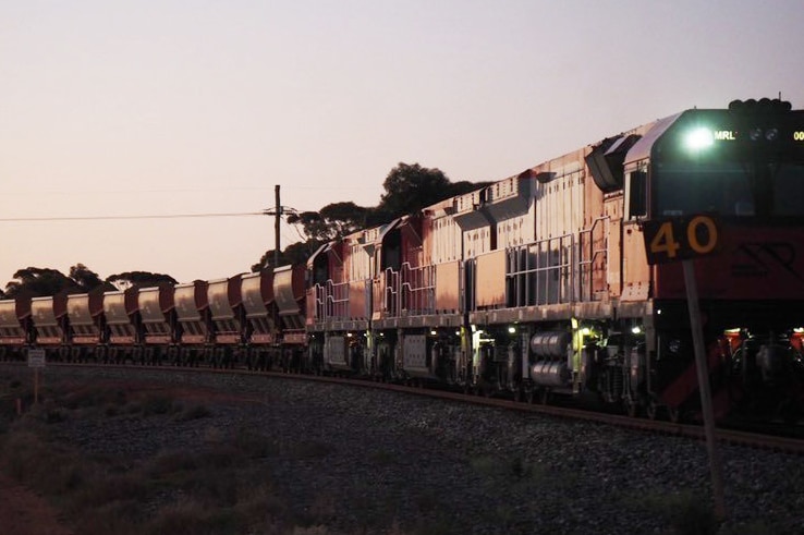 A train at sunset, full of iron ore on a remote track