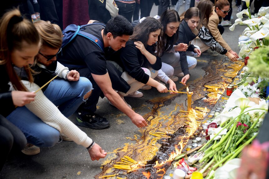 Students light candles at a shrine to victims of a school shooting in Belgrade