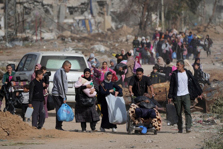 Displaced families from Gaza walking on the road. 