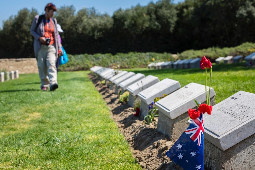 A tourist walks through war graves.