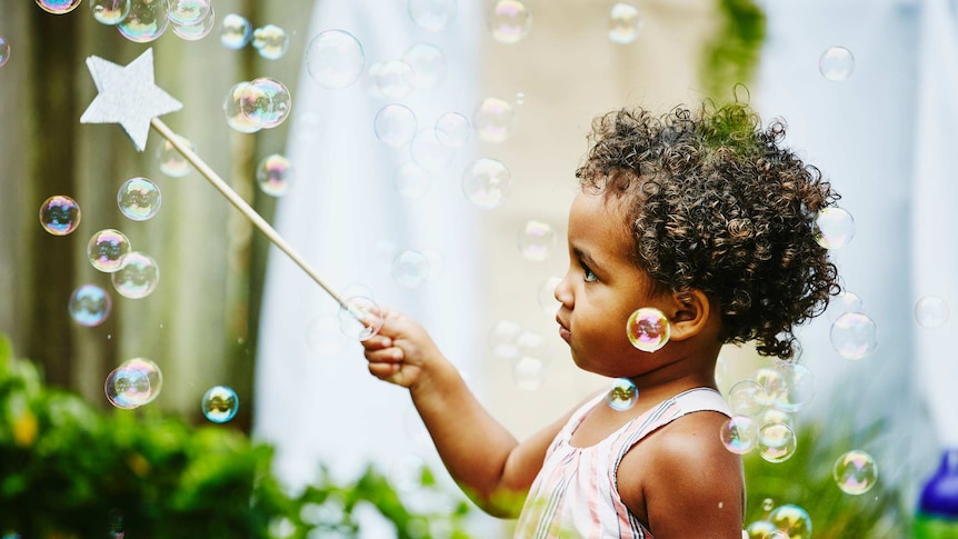 Toddler girl with star wand and bubbles
