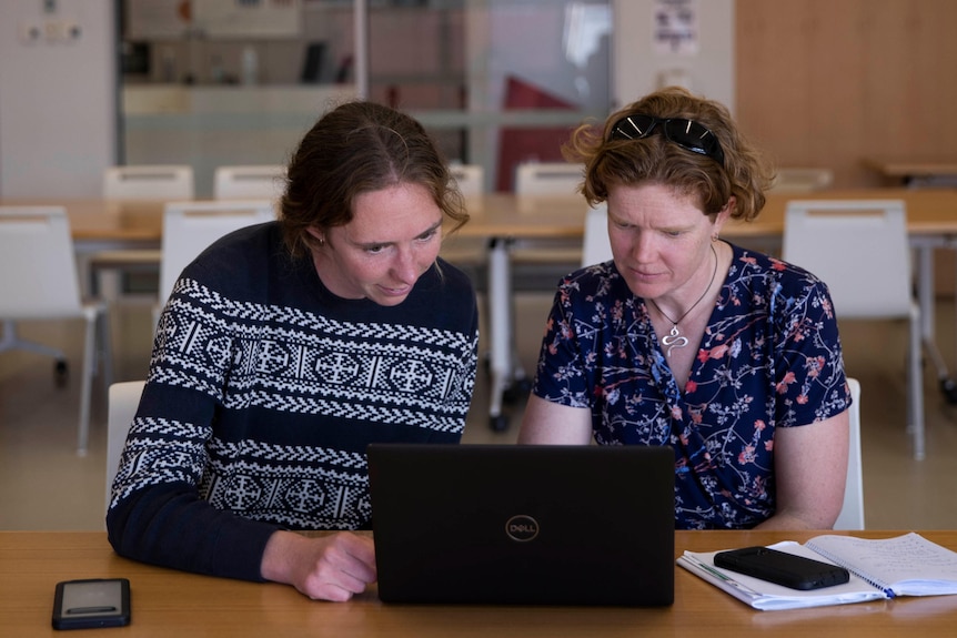 Penny Pascoe and Dr Julie McInnes look at a laptop computer while seated together.