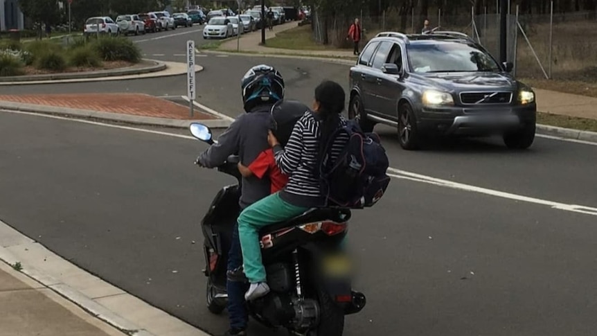 Scooter driver with two passenger without helmet