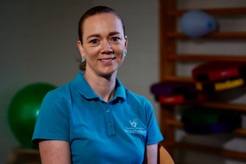 A woman wearing a blue polo in a gym