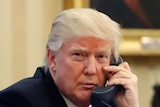 President Donald Trump speaks on the phone in the Oval Office