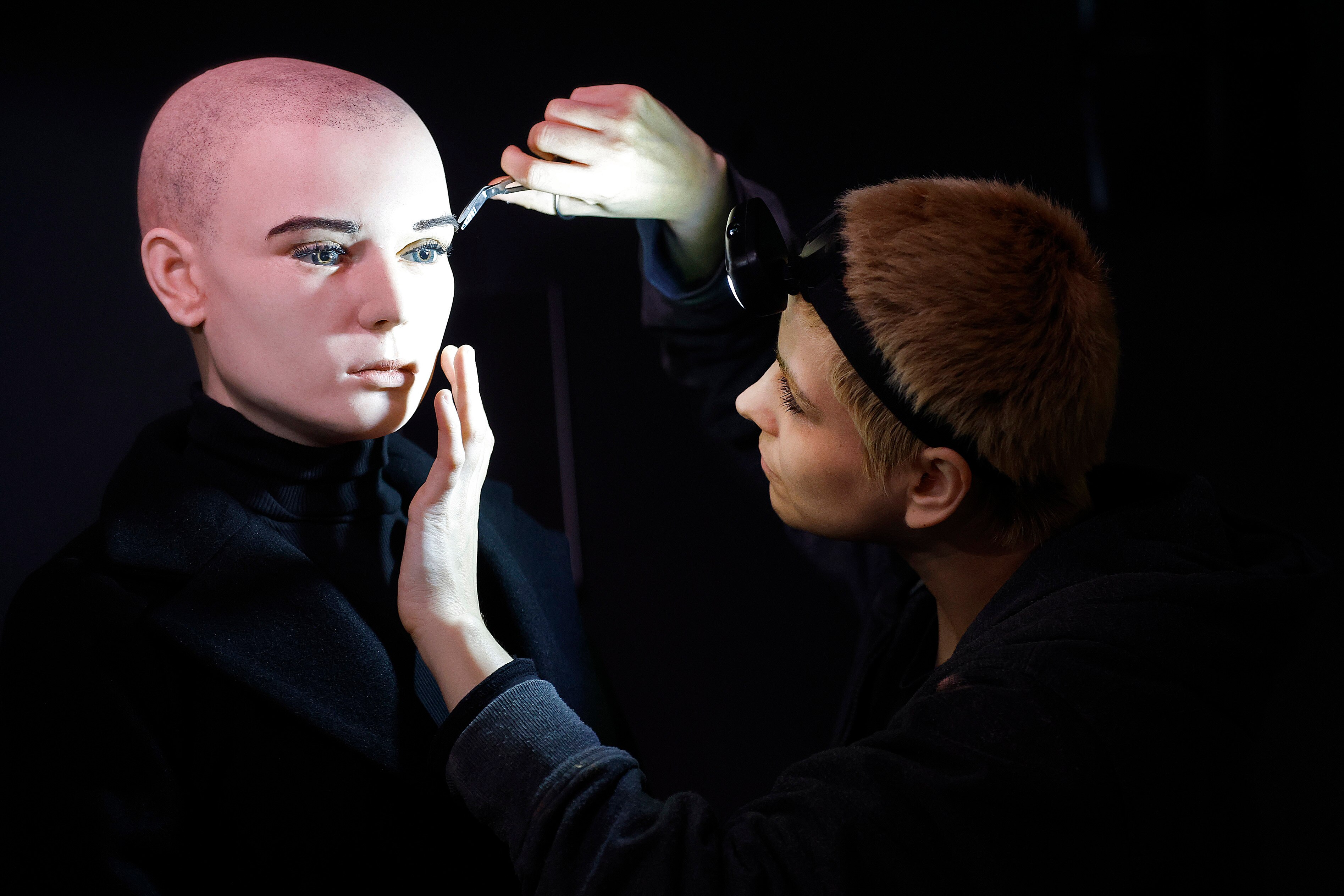 An artist trims the eyebrows on the Sinead O'Connor wax figure.