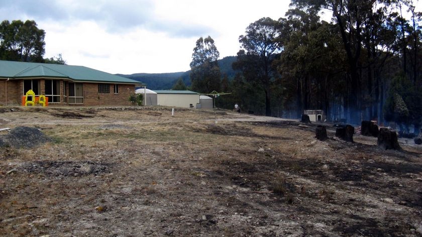 A house sits next to a patch of forest burnt by the Lachlan bushfire