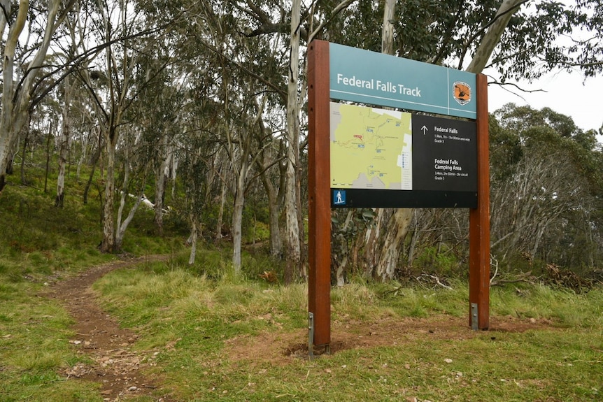 A sign for a walking track in bushland.