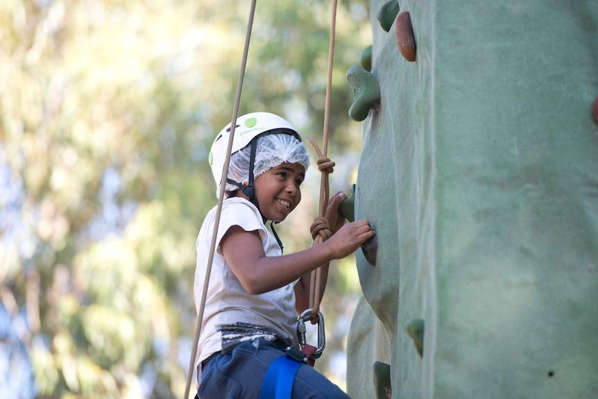 A child climbs on an artificial rockclimbing wall.