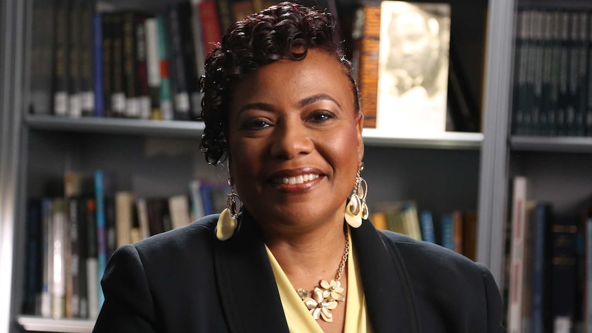 Dr Bernice King sits in front of a bookshelf